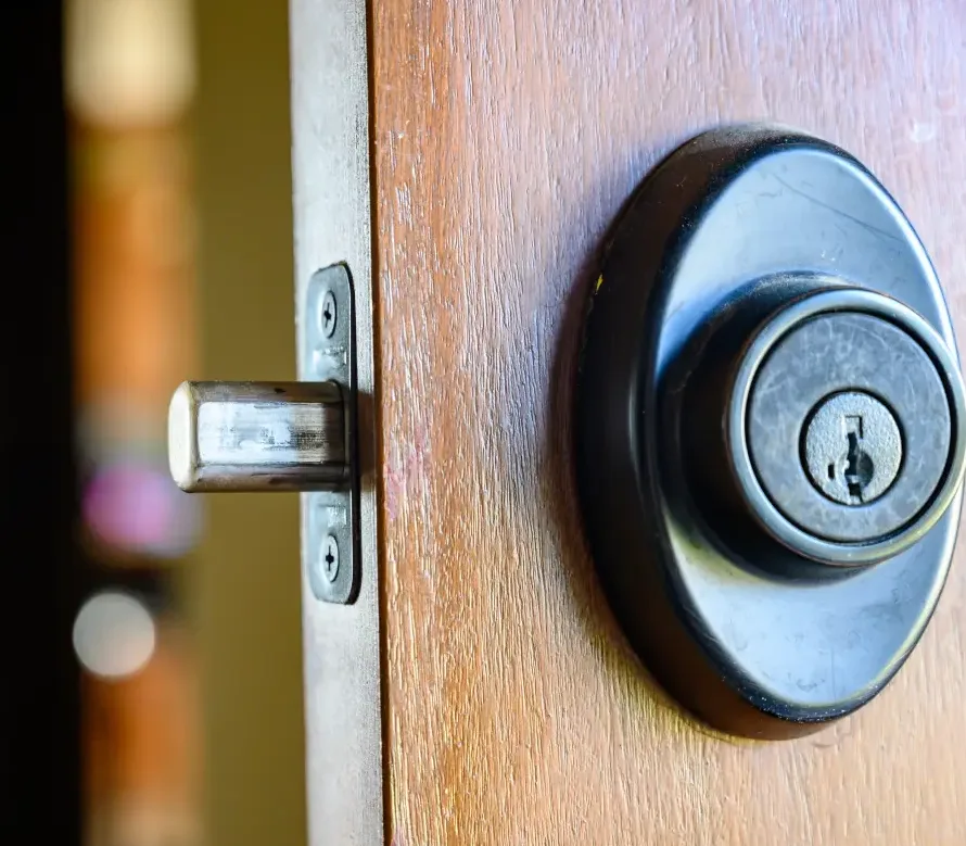 Locksmith drilling bore hole for new deadbolt installation on residential exterior door