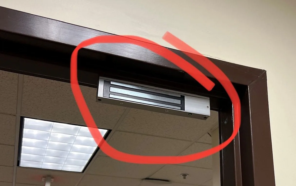 1200 lb electromagnetic lock installed on glass door with request-to-exit button by Triton Locksmith